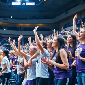 Kansas State women's basketball players in action during a game with enthusiastic fans in the background.